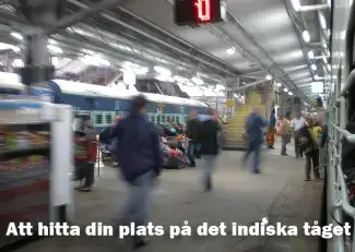 Kaotisk indisk järnvägsperrong med resande som skyndar längs tåget